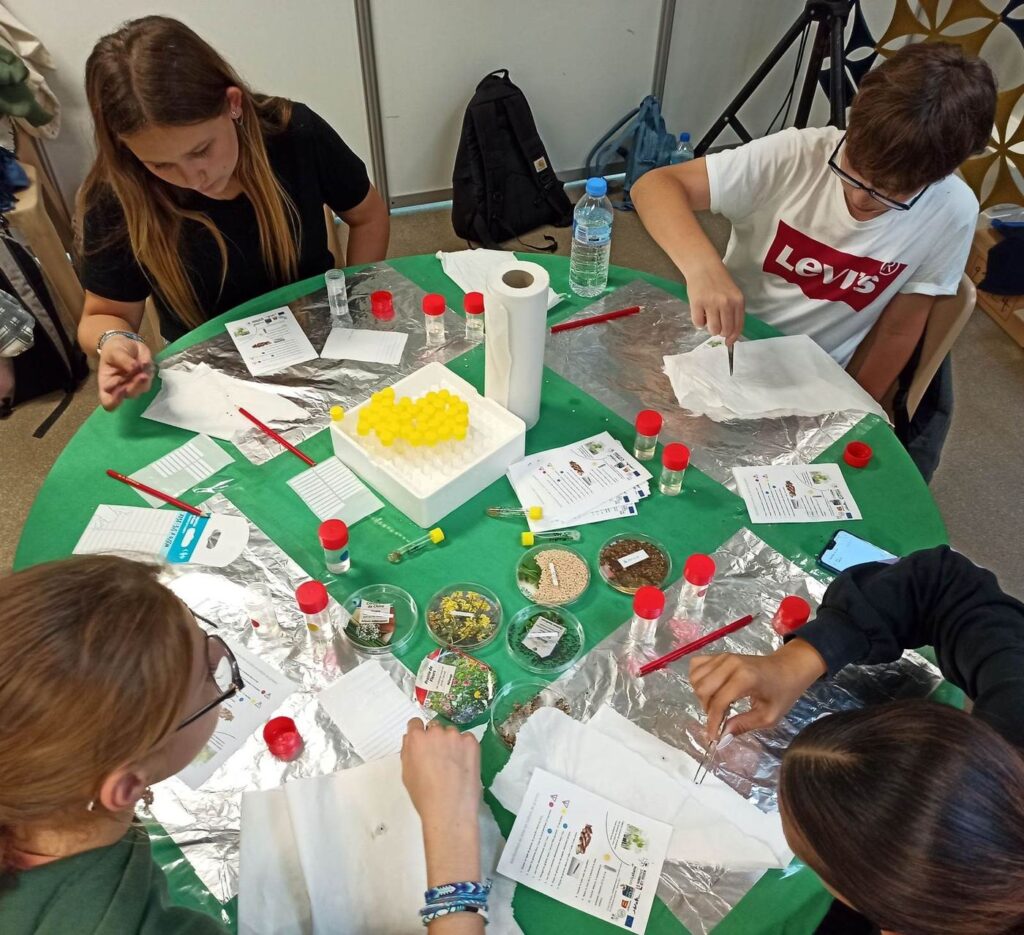 Des adolescents manipulent des échantillons de plantes et remplissent des fiches autour d'une table d'atelier.