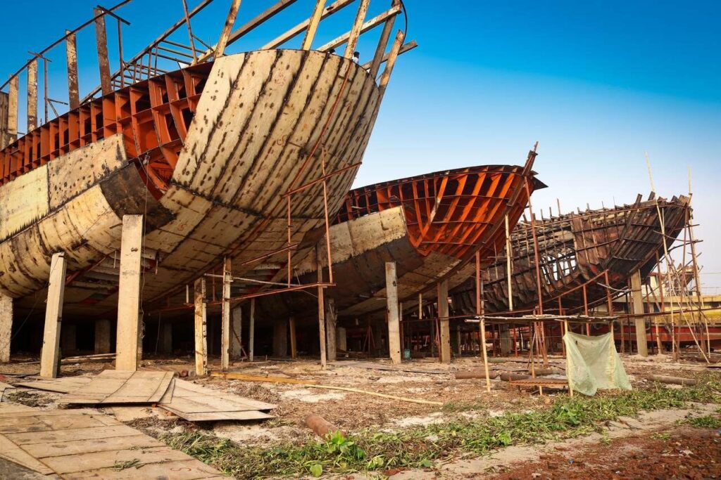 Coques de bateaux en bois en cours de construction sur un chantier.