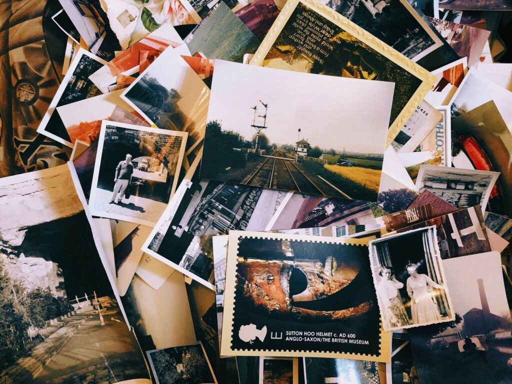 Tirages photographiques anciens éparpillés en désordre sur une table.