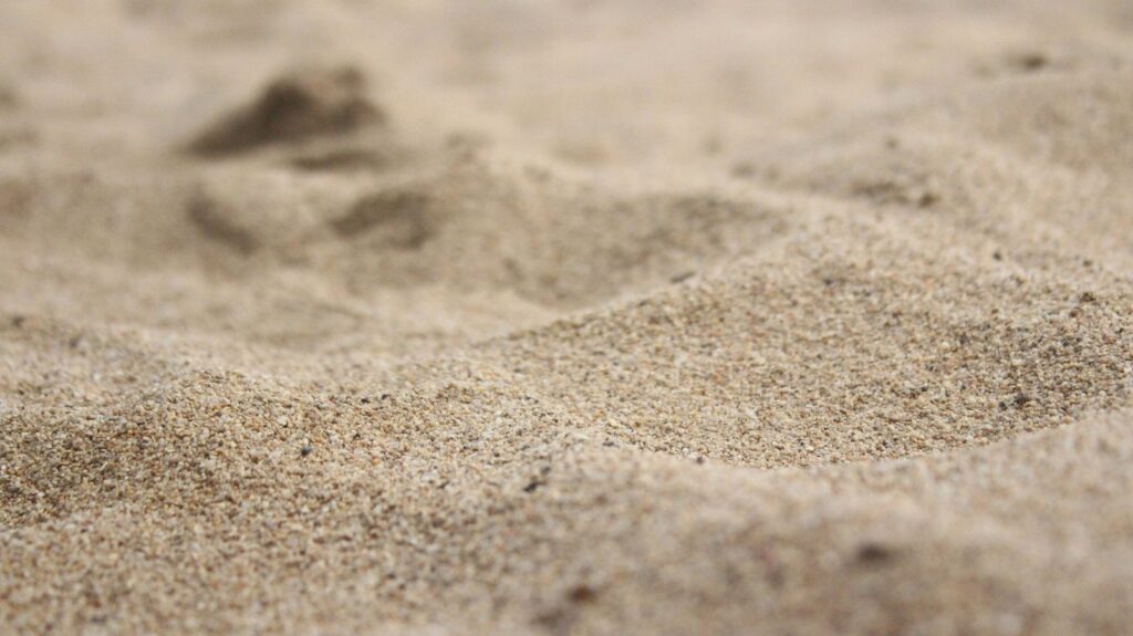 Sable fin marqué de traces, en gros plan.