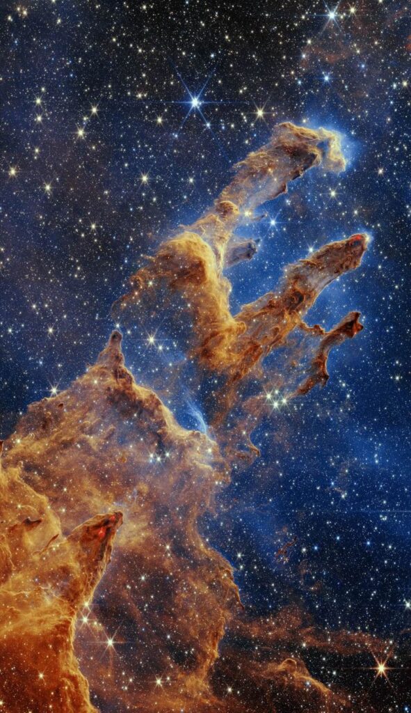 Colonnes de gaz et de poussière interstellaires photographiées dans l'espace, piquetées d'étoiles.