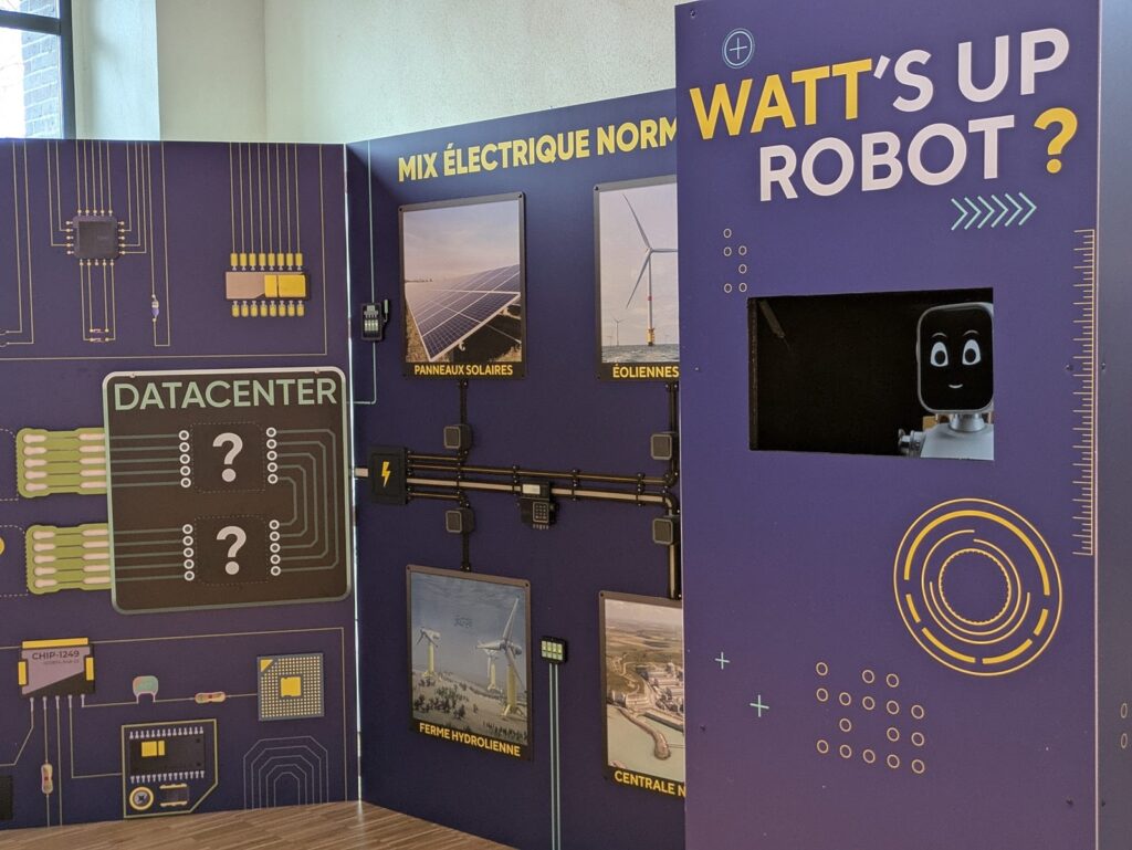 Panneaux d'exposition sur le mix électrique normand : datacenter, panneaux solaires, éoliennes et centrale hydroélectrique, à côté d'un écran intitulé « Watt's up robot ? ».