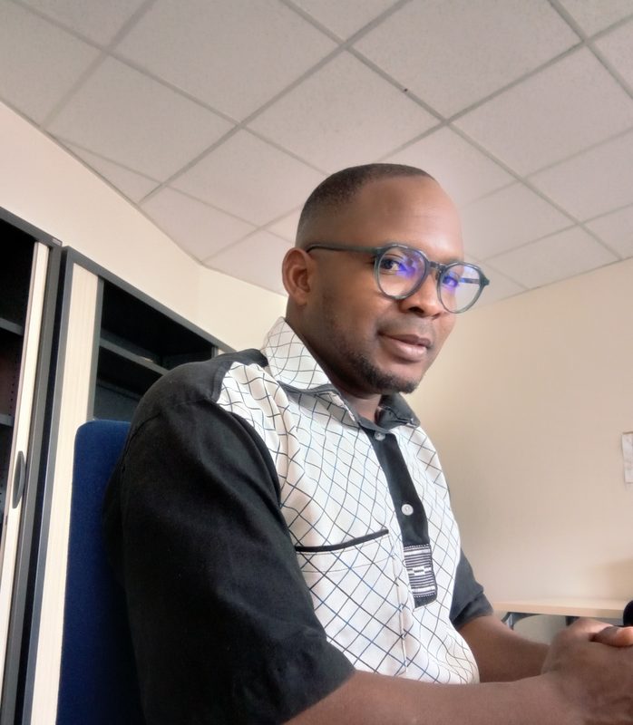 Jean-Baptiste Idani, doctorant en droit, assis à un bureau.