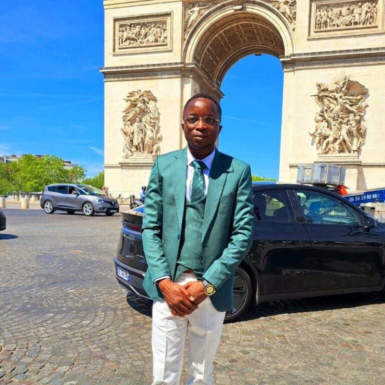 Portrait de Jean-Thierry Kubwimana, doctorant à l'IRSEEM, en costume, dans une rue.