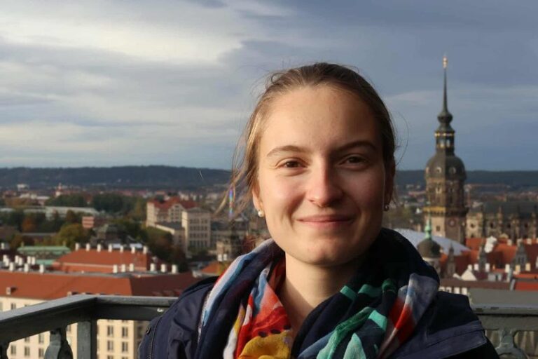 Portrait de Solène Perret, doctorante au laboratoire AIMS, devant les toits d'une ville.